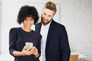 A man and a woman looking at a cell phone