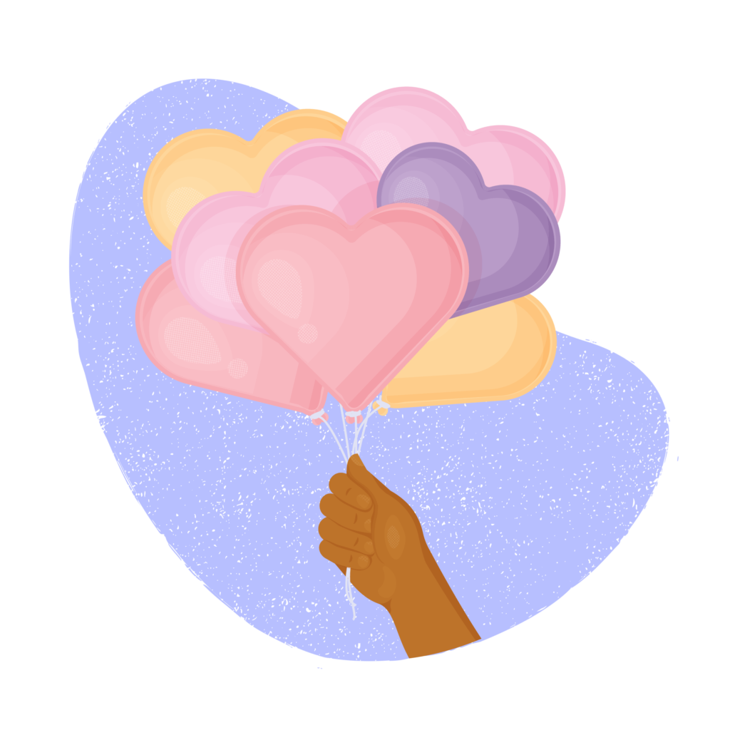 Hand holding heart shaped balloons.